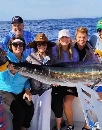 A large marlin being reeled in during a sportfishing charter.